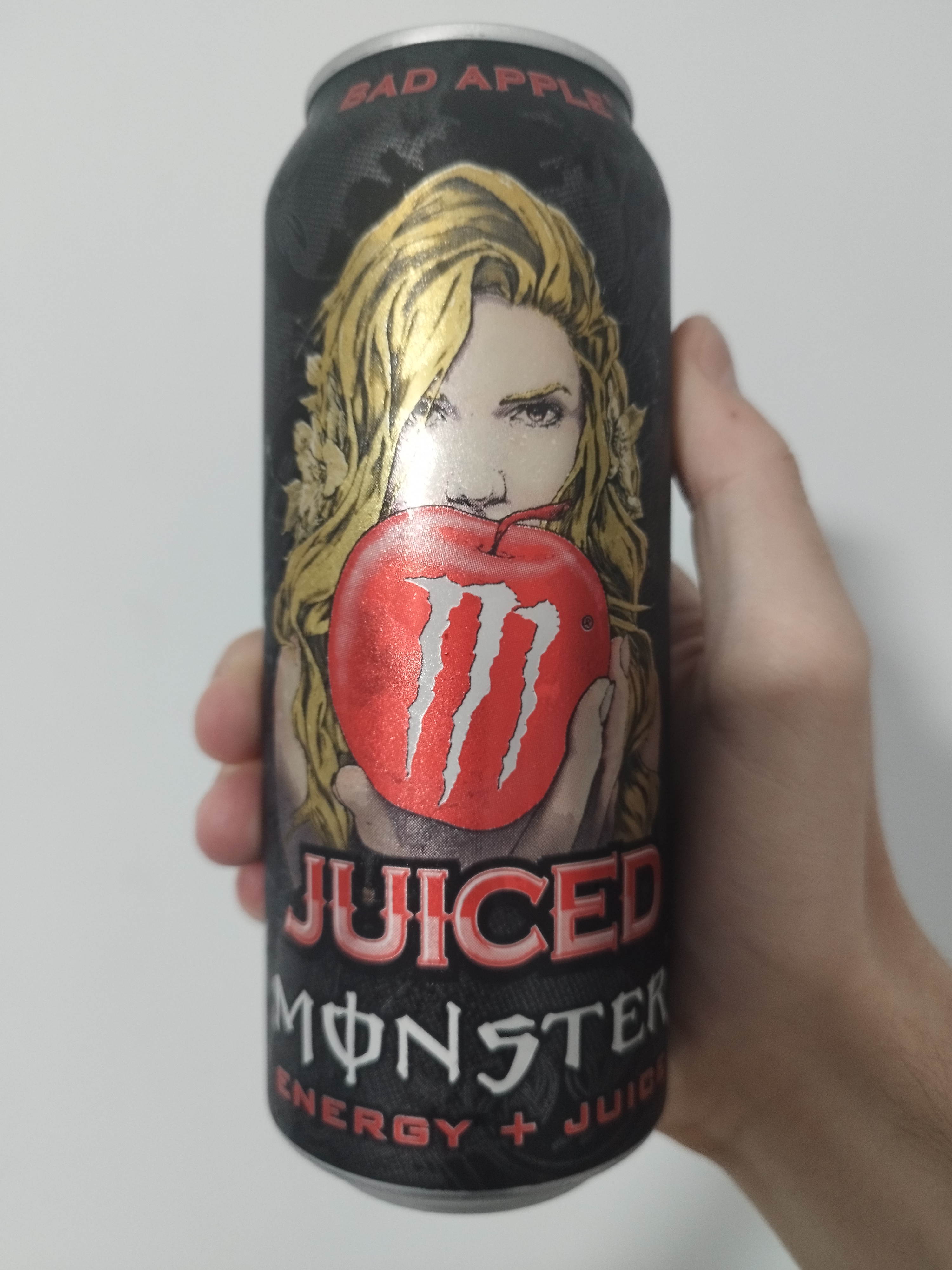 a black can of juiced monster bad apple. there is an illustration of eve, holding the forbidden fruit, depicted as an apple.
